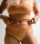 Angled front view of Kitty Latte nude thong underwear and matching camisole by Pretty Kitty Klub.